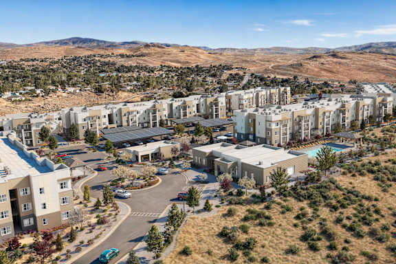 A large residential complex with a swimming pool and a parking lot.