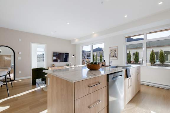 A modern kitchen with wooden cabinets and a large island.