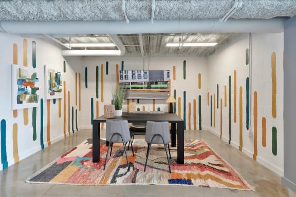 large work and multipurpose space with table, chairs, tv, and mural at The Citizen Birmingham