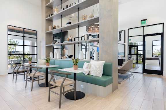 a seating area with two tables and a green bench