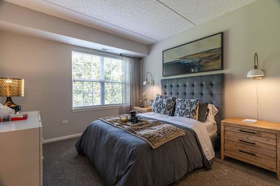 A bedroom with a large bed and a wooden nightstand.