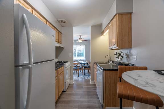 A kitchen with a refrigerator, table and chairs.