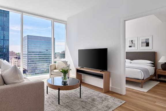 A modern living room with a large window overlooking the city.