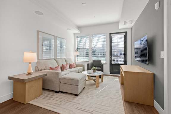 A living room with a couch, a coffee table, and a lamp.