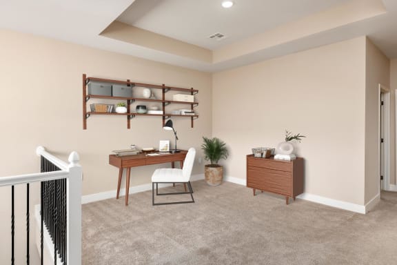 the study area of a manufactured home with beige walls and carpet