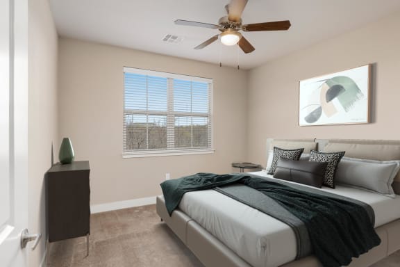 a bedroom with a ceiling fan and a large window