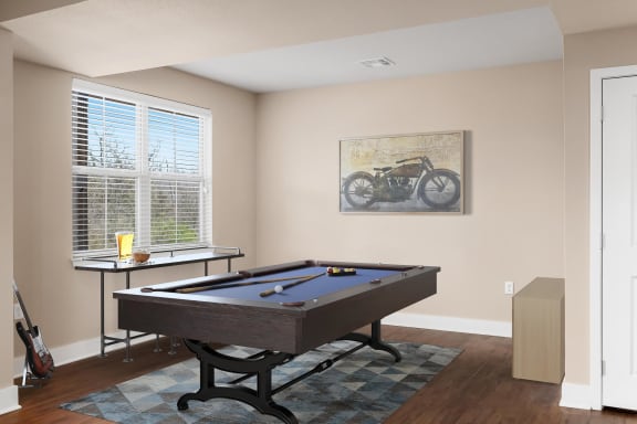 a games room with a billiard table and a vintage motorcycle on the wall
