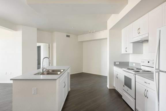 A white kitchen with a sink and stove.