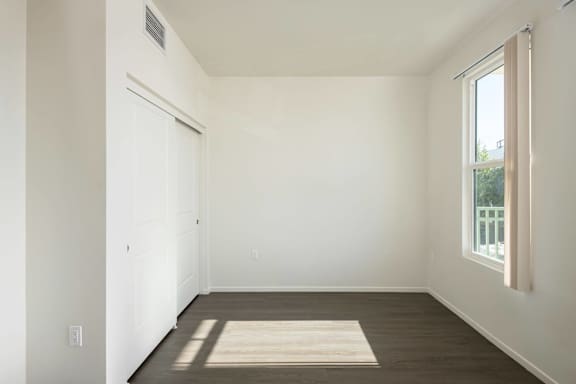 A room with a rug on the floor and a window on the right side.