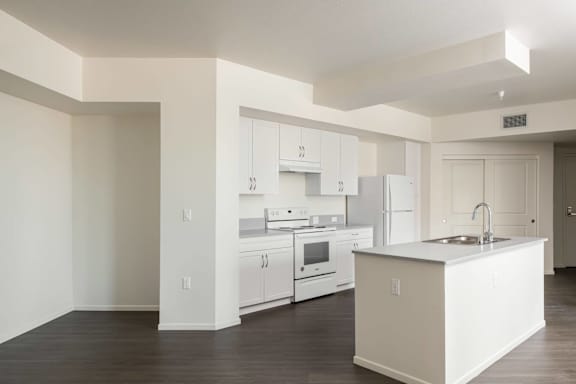 A kitchen with white appliances and cabinets.