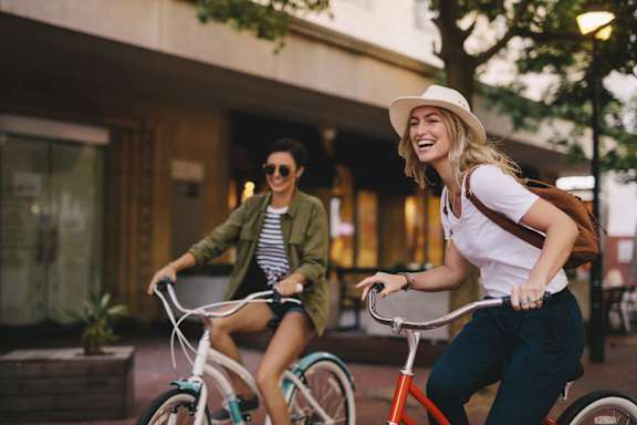 Two people riding bicycles in an urban setting.