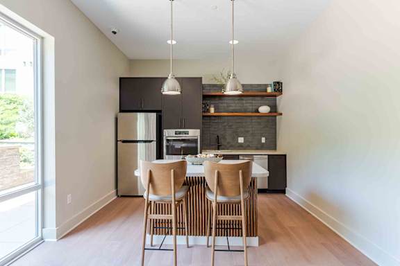 A kitchen with a refrigerator, oven, and sink.
