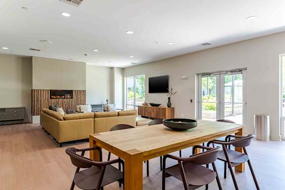 A modern dining room with a wooden table and chairs.