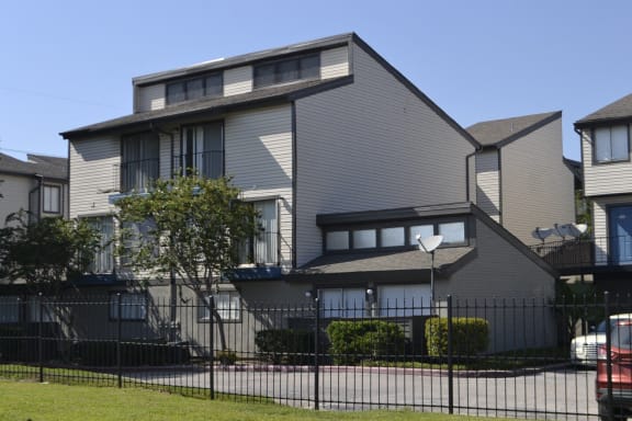 a gray house with a fence in front of it