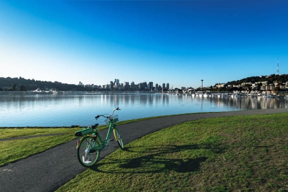 a bike parked on a path next to a body of water