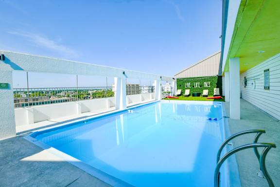 A large outdoor swimming pool with a white fence around it.