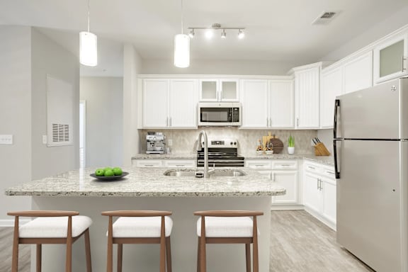 A kitchen with a granite countertop and white cabinets.