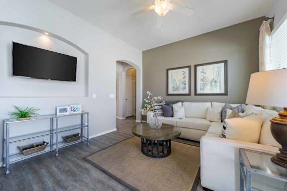A living room with a white couch, a television, and a coffee table.