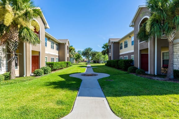Pathway through the grassy area  at Pavilions at Northshore Apartment Homes, Portland, Texas, 78374