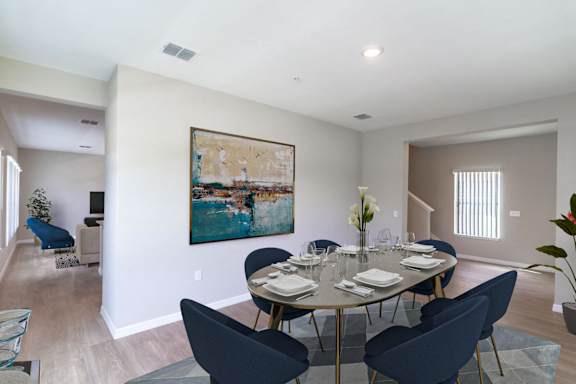 A dining room with a round table set for six.