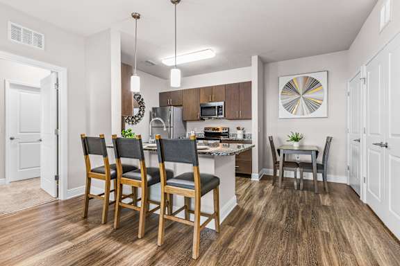 A kitchen with a dining table and chairs.
