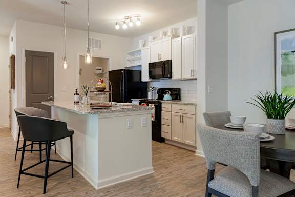 A modern kitchen with a stainless steel refrigerator and grey cabinets.