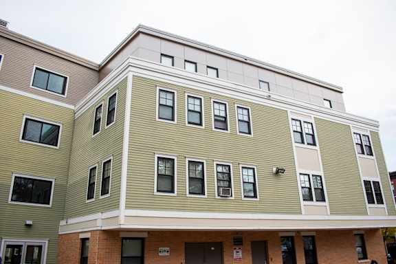 a large apartment building with green and white siding