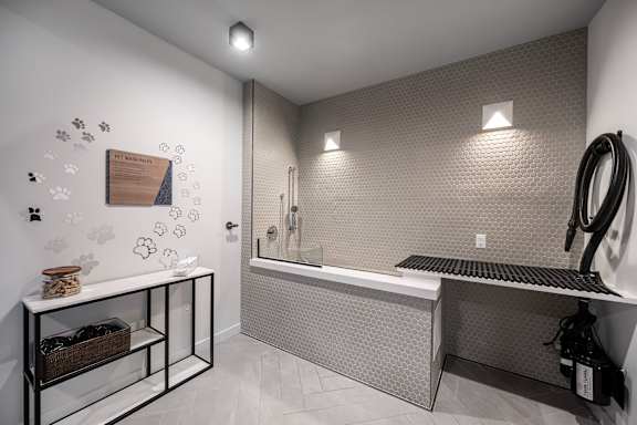 A bathroom with a tub, sink, and a shelf with baskets.