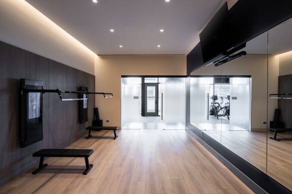 a gym with wood floors and a large screen tv on the wall