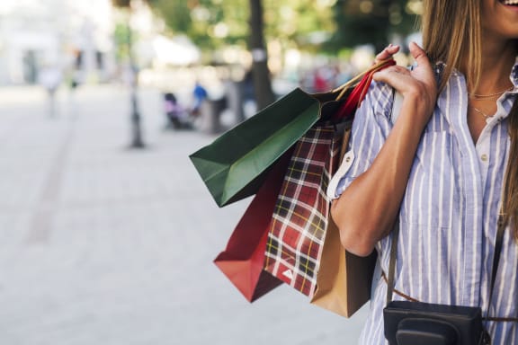 a woman walking down the street holding two shopping bagsat Novella Biltmore, Phoenix, AZ