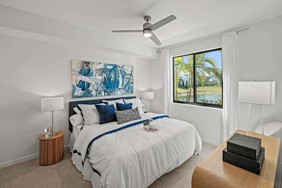 A bedroom with a large bed and a painting on the wall