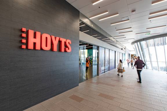 people walking through a building with a hovis sign on the wall