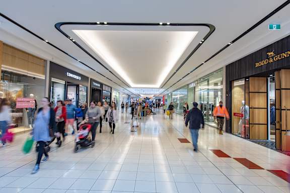 people walking through a mall in a shopping center