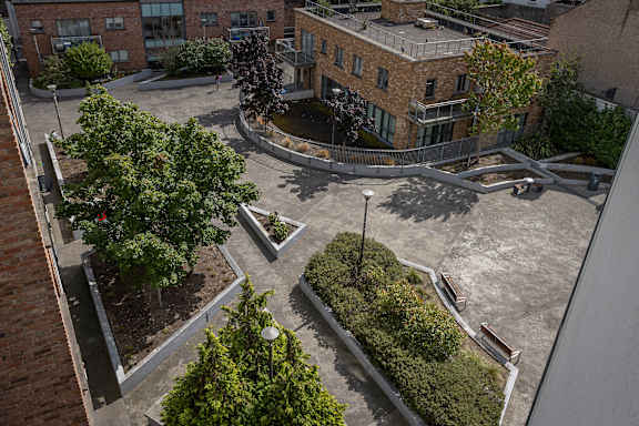 an aerial view of a courtyard with trees and buildings