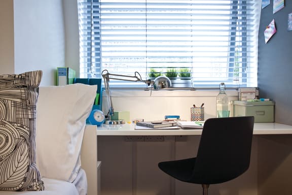 a desk with a chair in front of a window