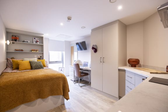 a bedroom with a bed and a desk with a computer