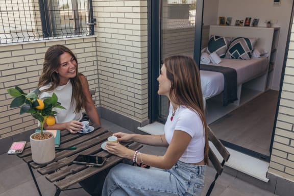 two women sitting at a table drinking coffee
