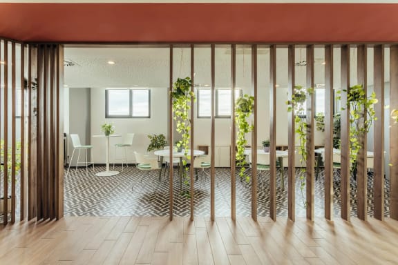 a room with tables and chairs and plants in it