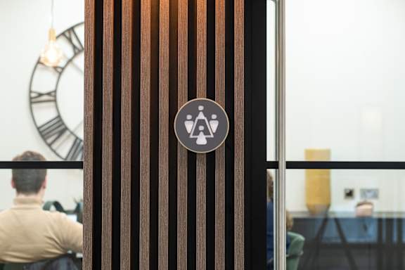 a sign on a glass door with a man sitting in a chair