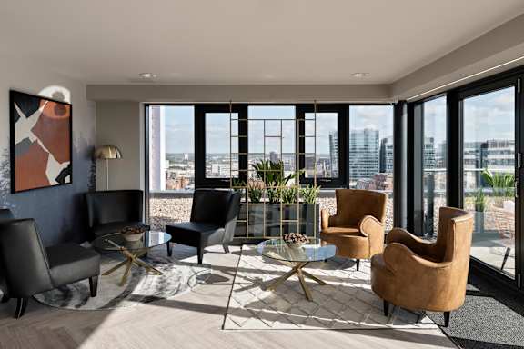 a living room with a view of a city and a table and chairs