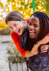 Two women hugging each other in a park.