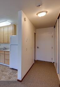 A kitchen with a white refrigerator and a stainless steel sink.