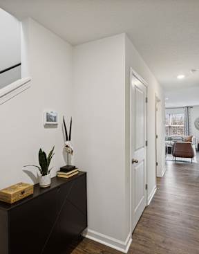 a hallway of a home with white walls and wood flooring and a door at The Summit Townhomes in Oak Ridge, Tennessee 37830