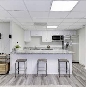 A kitchen with a bar area and stools.