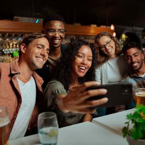 A group of friends taking a selfie in a bar.