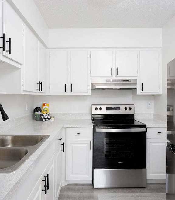 a kitchen with white cabinets and black and white appliances