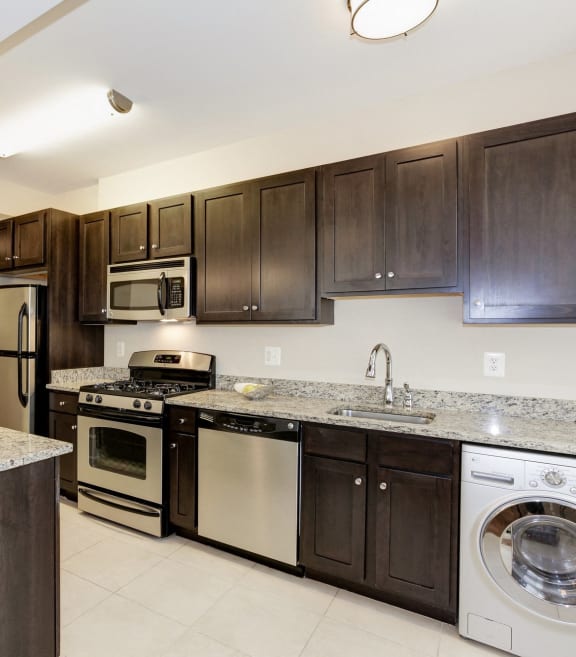 a kitchen with dark wood cabinets and a white counter top