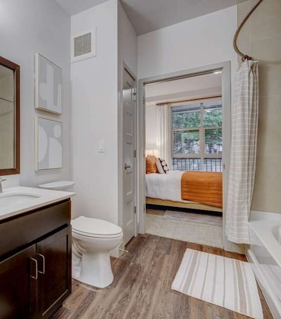 A bathroom with a toilet, sink, and mirror.