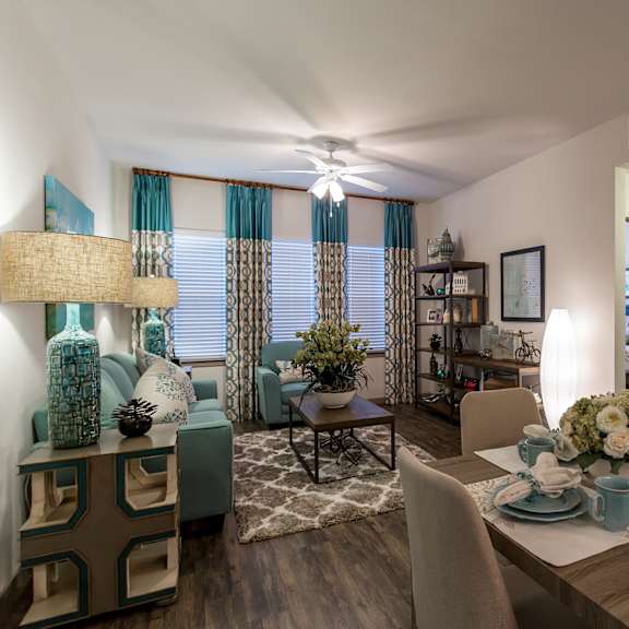 an open concept living room and dining area with a white dining table and rattan chairs