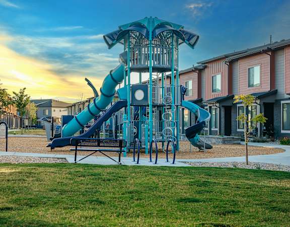 Young girl sliding down a yellow slide at H2O Townhomes, Utah, 84119